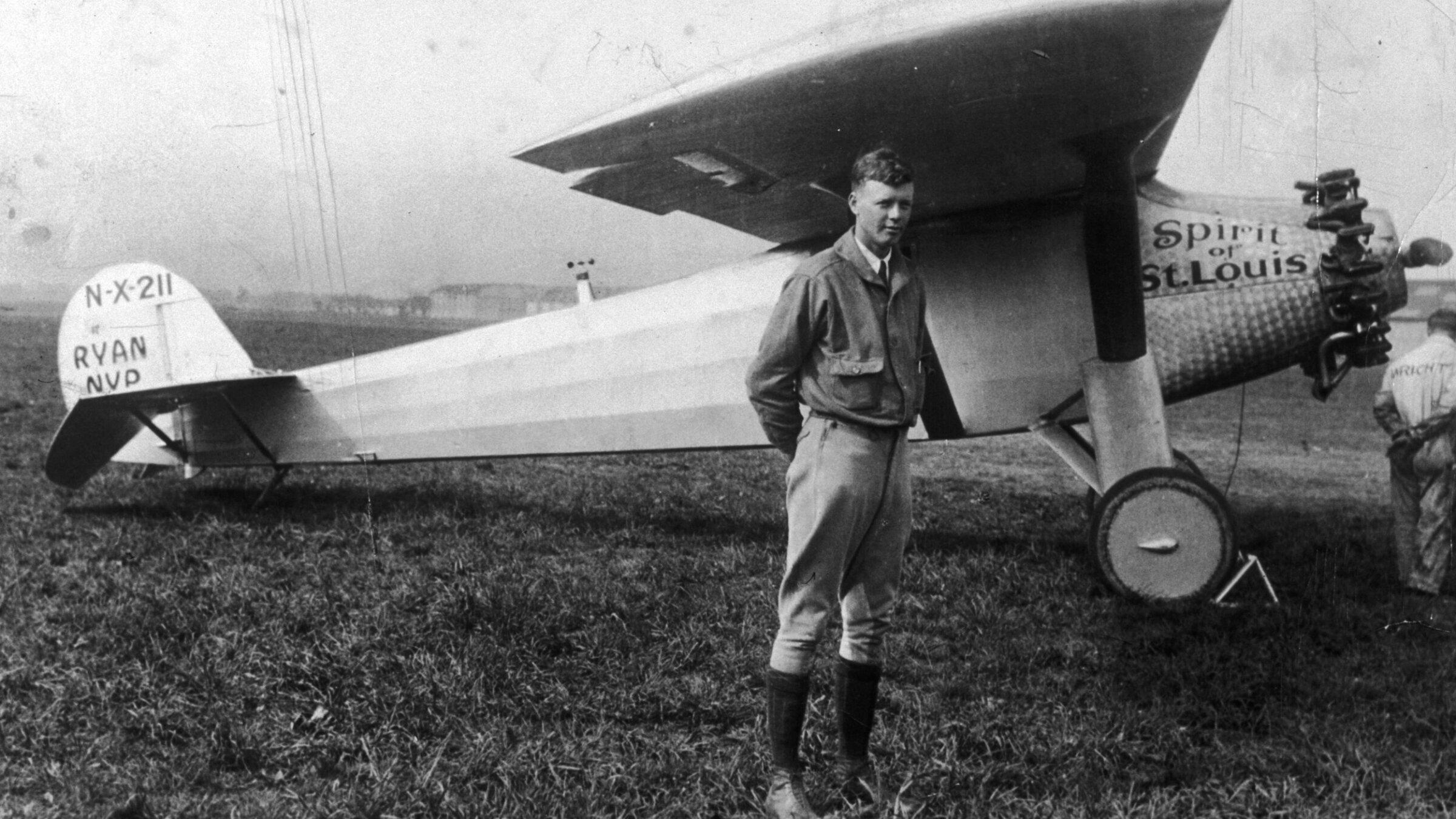 Charles Lindbergh posing under the wing of his Ryan monoplane, named the Spirit of St. Louis.