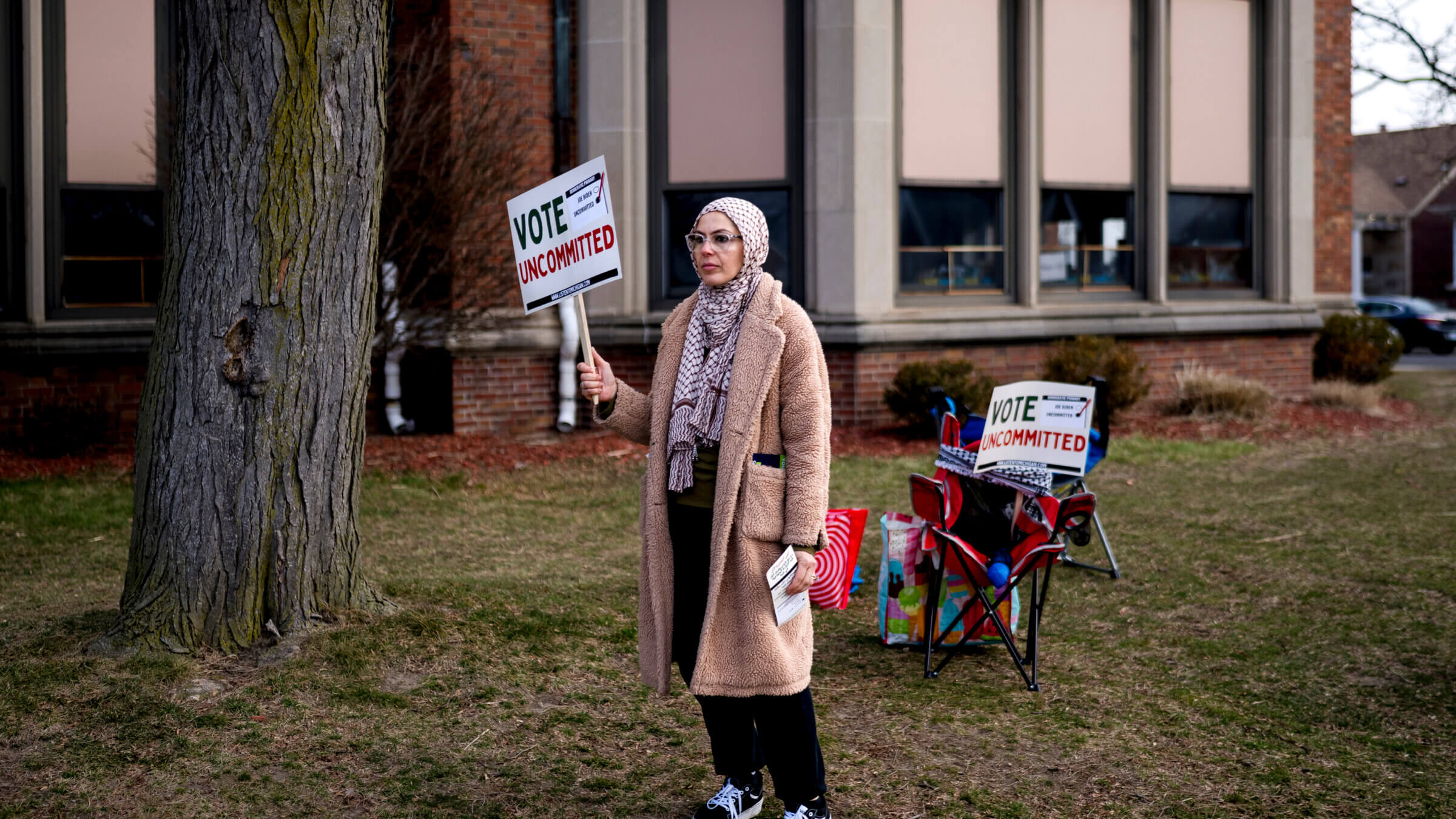 A volunteeer holds a "Vote Uncommitted" sign outside of a polling station in Dearborn, Michigan on Feb. 27, 2024.