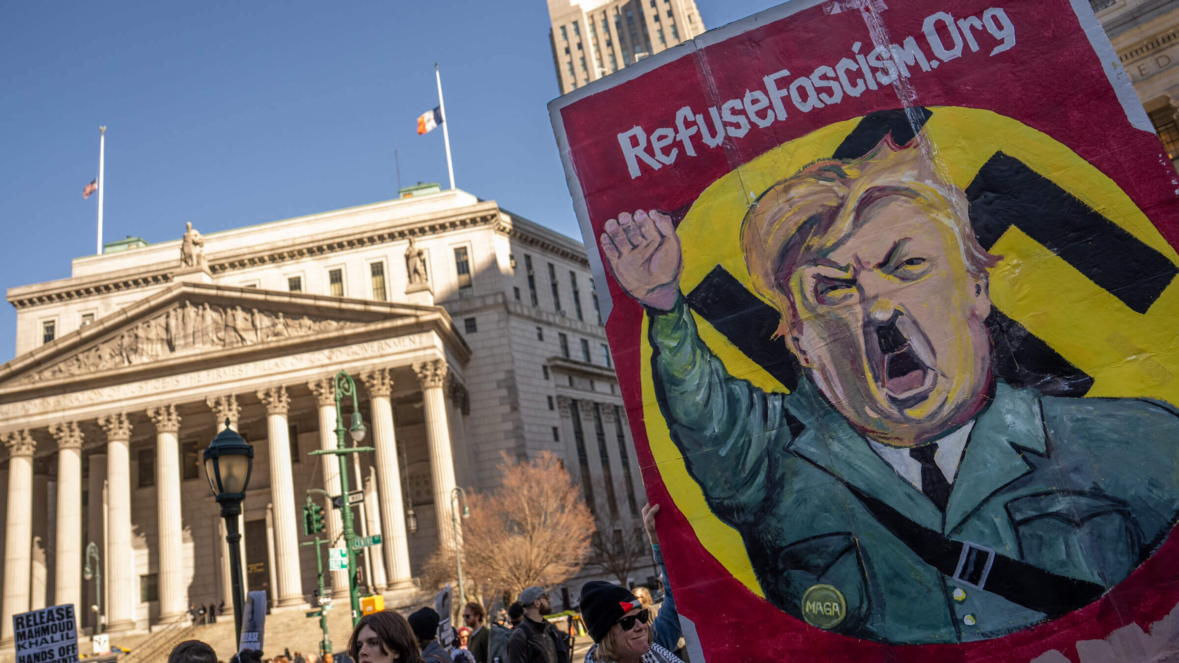 A sign depicts President Donald Trump as Adolf Hitler during a rally to demand the release of Mahmoud Khalil in New York.