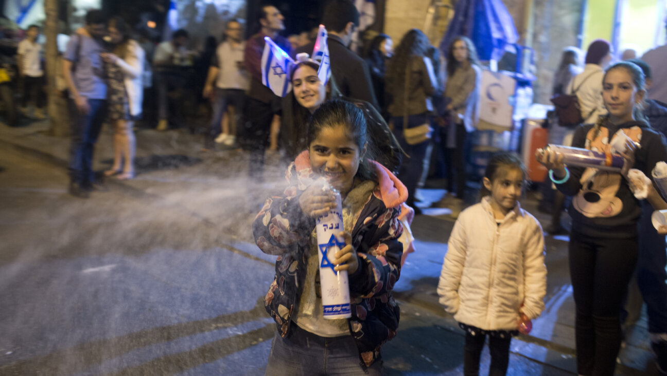 An Israeli girl sprays foam during 2017 Yom Ha'atzmaut celebrations in Jerusalem. Students from a Jewish school were attacked April 30 by Israeli teens in Tiberias after foam-spraying got out of hand.