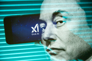 Double exposure photograph of a portrait of elon musk and a person holding a telephone displaying the Grok artificial intelligence logo.